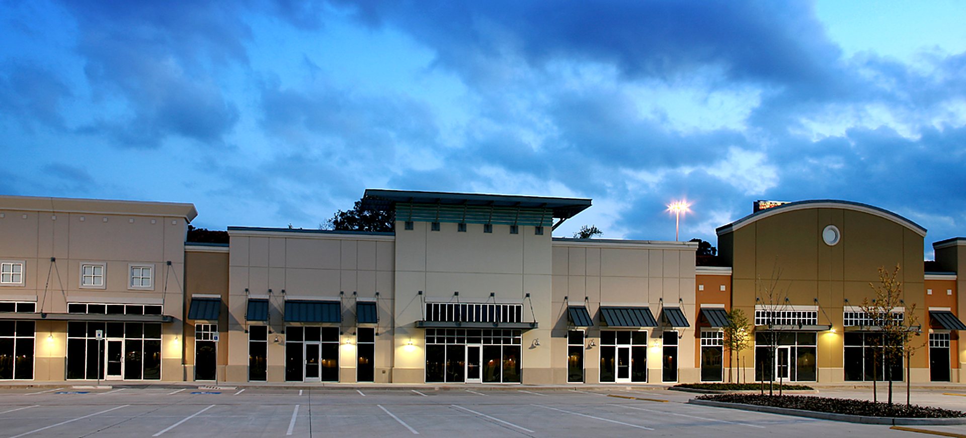 Multi-tenant retail center storefronts at dusk